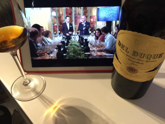 Imagen de una copa de amontillado Del Duque junto a su botella y un iPad en el que se ve un cata virtual de Antonio Flores, enólogo de González Byass